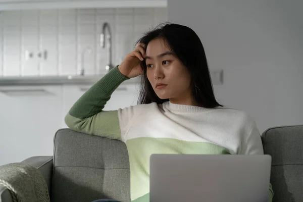 Worried Anxious Asian Girl Sitting Laptop Sofa Looking Aside Sad — Stock Photo, Image