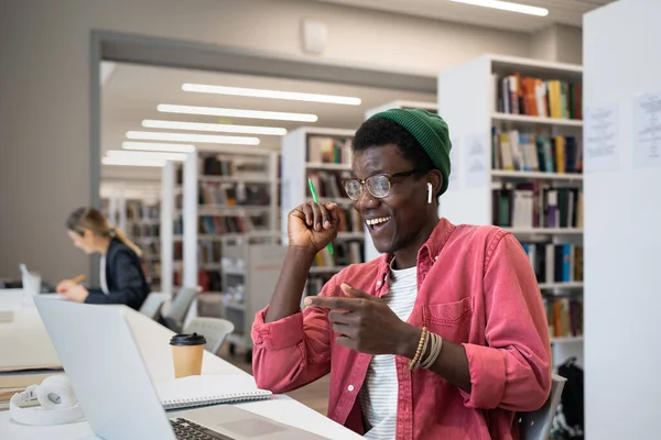 Позитивный Молодой Африканский Мужчина Репетитор Наушниках Дистанционно Работающий Ноутбуке Библиотеке — стоковое фото