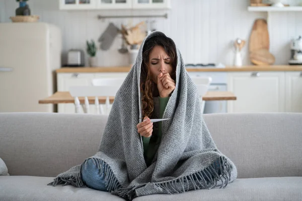 Frightened Unhealthy Woman Looking Thermometer Sits Wrapped Warm Plaid Sofa — Stock fotografie