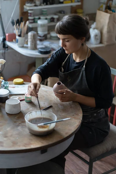 Konzentrierte Keramikerin Die Der Werkstatt Arbeitet Sitzt Tisch Und Dekoriert — Stockfoto