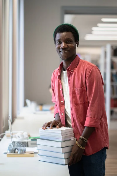 Молодой Веселый Афроамериканец Библиотекарь Улыбается Камеру Стоя Грудой Книг Публичной — стоковое фото