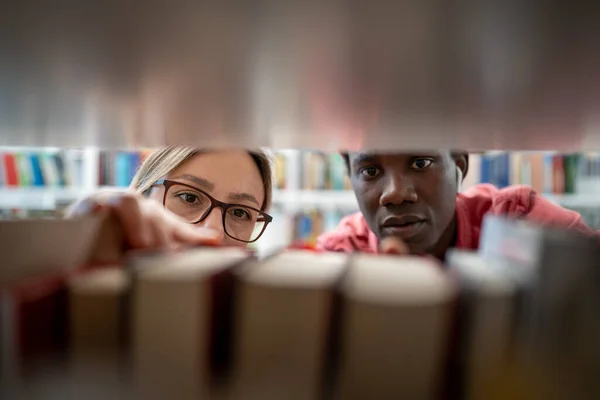 Geïnteresseerde Gefocuste Multinationale Studenten Zoeken Naar Benodigde Informatie Bibliotheekboeken Terwijl — Stockfoto