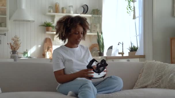 Joven Mujer Afroamericana Curiosa Sentada Sofá Casa Sosteniendo Casco Mujer — Vídeos de Stock