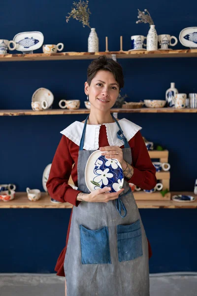 有自信的企业家在制陶工作室里为妇女制作手工艺品陶器盘 成功的陶瓷工作室老板在工作场所摆设手工制版 — 图库照片