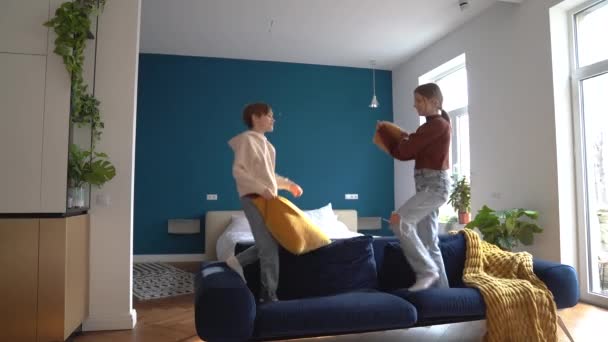 Aufgeregt Fröhliche Kinder Geschwister Kissen Kämpfen Auf Der Couch Spaß — Stockvideo