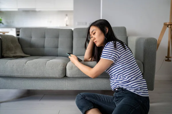 Downcast Asian Woman Looking Sadly Device Screen Reading Unpleasant Message — Stock Photo, Image