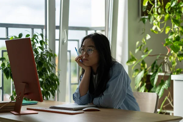 Penzív Koreai Diáklány Szemüvegben Asztalnál Nézi Képernyőt Webinar Videót Néz — Stock Fotó
