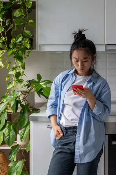 Serieuze Aziatische Vrouw Die Thuis Keuken Staat Een Mobiele Telefoon — Stockfoto