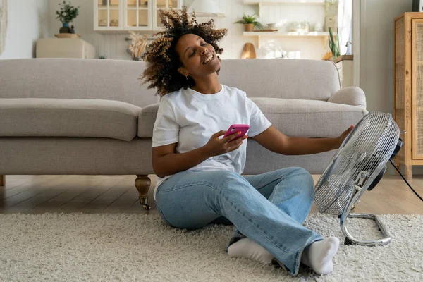 Fröhliche Afroamerikanerin Kühlt Sich Mit Elektroventilator Und Erfreut Sich Kühler — Stockfoto