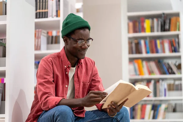 有兴趣的非裔美国学生在大学图书馆看书 文学爱好者花时间在书店里看一本有趣的小说 戴眼镜 读书准备考试的黑人 — 图库照片