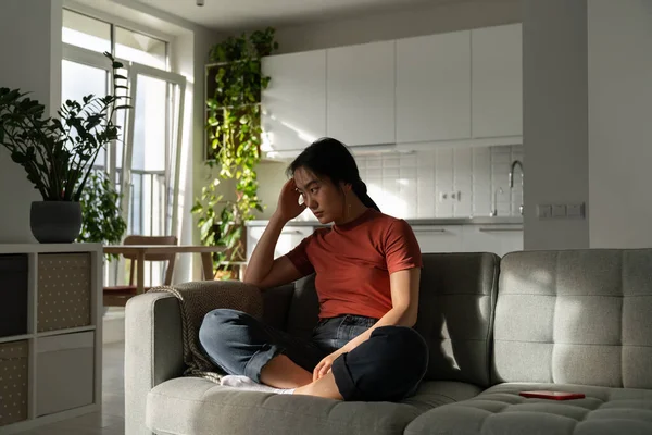 Osamělá Zamyšlená Asijská Dívka Sedí Pohovce Obývacím Pokoji Čeká Telefonát — Stock fotografie