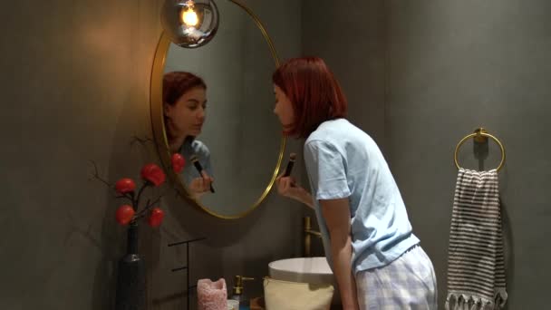 Mulher Agradável Sorri Piscadelas Olhar Espelho Banheiro Aplica Lentamente Maquiagem — Vídeo de Stock