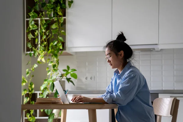 Focused Asian Woman Freelancer Working Remotely Sits Table Laptop Kitchen — Stock Photo, Image