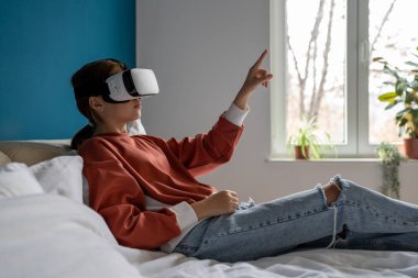 Sanal gerçeklik kulaklığı takan genç bir kız dijital dünyayla etkileşime giriyor, meraklı bir kadın VR ile birlikte evreni keşfediyor ve evde yatıyor. İnsanlar ve üç boyutlu metaevreni keşfetme deneyimi