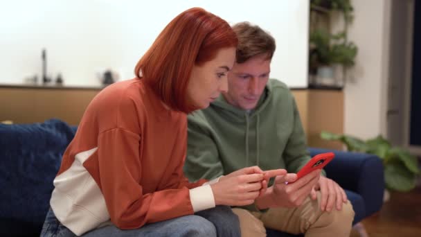 Nadšený Šťastný Pár Sedí Gauči Při Pohledu Smartphone Čtení Dobré — Stock video