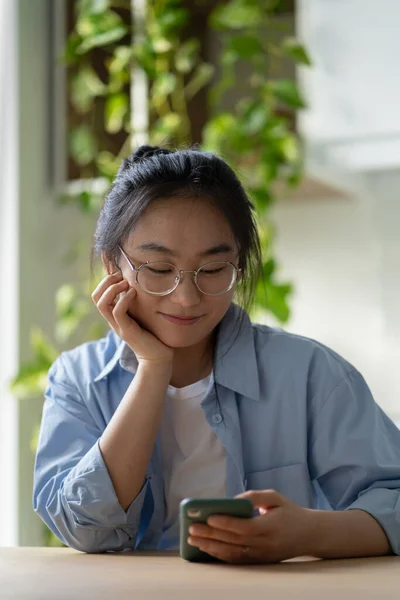 Good Natured Satisfied Asian Korean Woman Stylish Glasses Looks Mobile — Stock Photo, Image