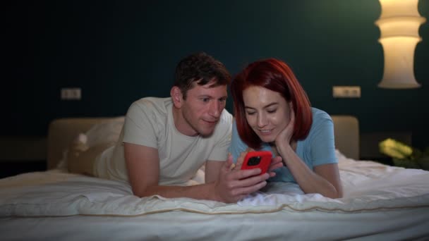 Gelukkig Huwelijkspaar Ligt Bed Leest Goed Nieuws Het Telefoonscherm Spannende — Stockvideo