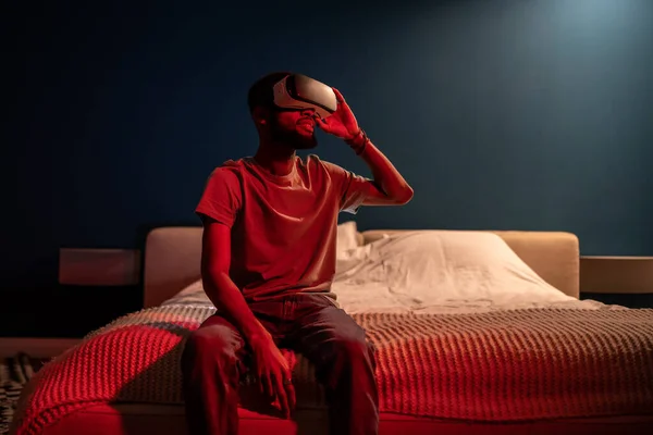 Siyah Adam Evde Gece Yatağında Oturan Neon Işıklı Sanal Gerçeklik — Stok fotoğraf