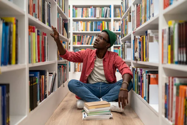 Sebevzdělání Mladý Afroameričan Sedí Podlaze Knihovně Mezi Regály Tráví Čas — Stock fotografie