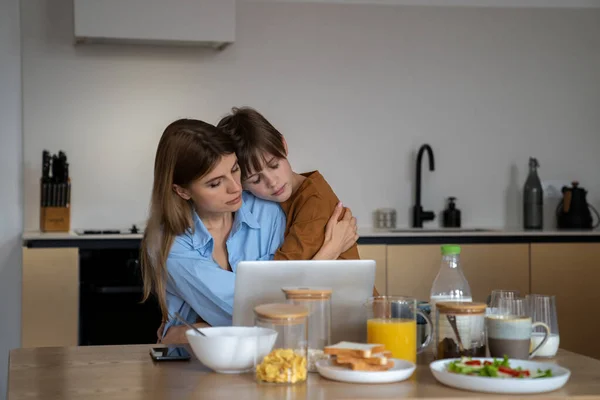 Uykucu Evlat Annesine Sarılıyor Dizüstü Bilgisayarda Çalışıyor Mutfakta Oturmuş Kahvaltı — Stok fotoğraf