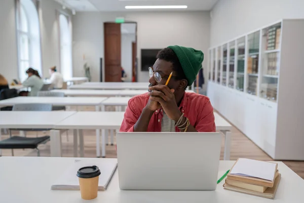 Estudante Nerd Jovem Afro Americano Pensativo Estudando Biblioteca Usando Laptop — Fotografia de Stock
