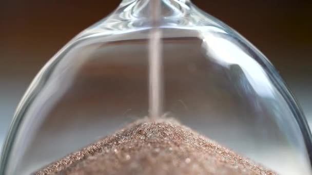 人生の推移として一定の時間を持続反転砂時計で実行している光沢のある砂 期限までの通過時間を測定するホームアクセサリー 小さな砂の粒がガラスフラスコの穴に落ちる — ストック動画