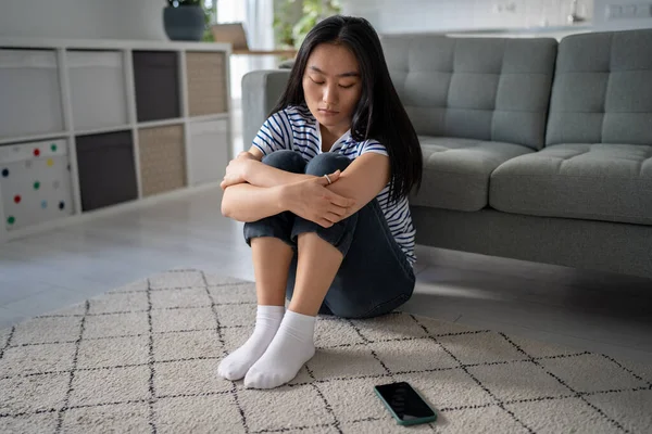 Infeliz Chica Asiática Deprimida Sentada Suelo Casa Mirando Teléfono Inteligente —  Fotos de Stock