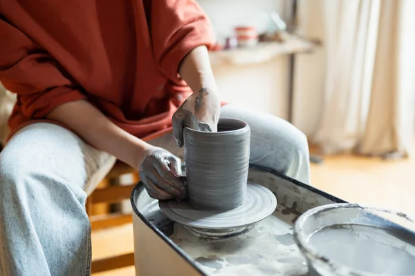手工操作的女陶工坐在舒适的车间里 用陶瓷轮做陶瓷餐具 在艺术工作室为创意企业家和工匠创造手工瓷器的过程 — 图库照片