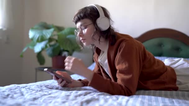 Défilement Dépendance Hipster Girl Portant Des Écouteurs Regardant Écran Smartphone — Video