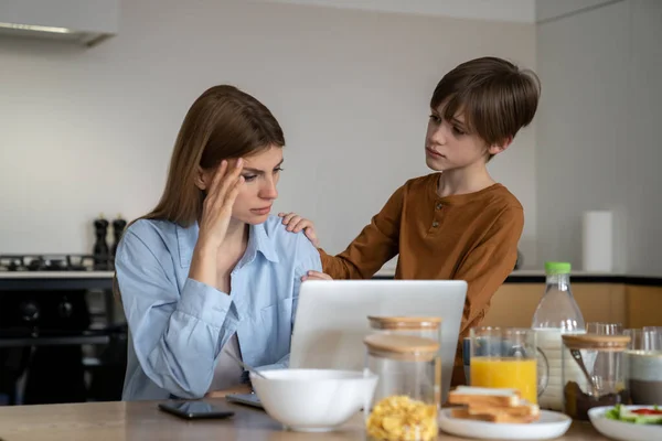 어머니는 아이를 데리고 집에서 일하고 노트북 화면을 집중하려고 노력한다 사랑하는 — 스톡 사진