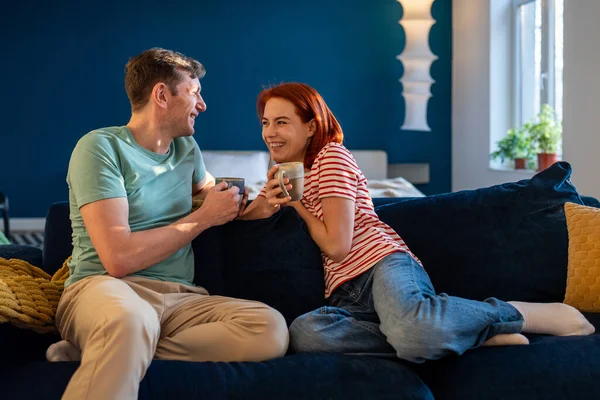 若い幸せなロマンチックな家族のカップルの話と笑顔 お互いをよりよく知るようになり お茶を飲み 自宅でソファの上に座って 一緒に時間を過ごす 関係のコミュニケーション結婚への愛 — ストック写真