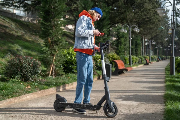 Millennial Hipster Gars Activer Scooter Électrique Partir Smartphone Dans Parc — Photo