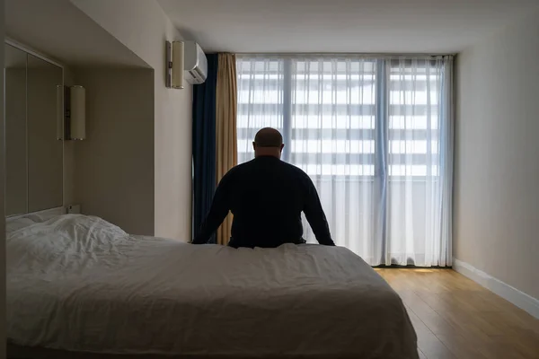 Грустный Жирный Одинокий Мужчина Сидит Кровати Отеле Смотрит Окно Отдыхая — стоковое фото