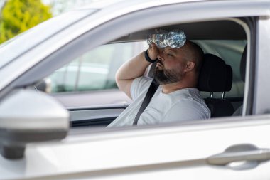 Overweight man drives car with broken air conditioner in hot summer weather. Weary male presses bottle of water to face to cool off suffering from heat, stuffiness. Exhausted tired overheated man. clipart