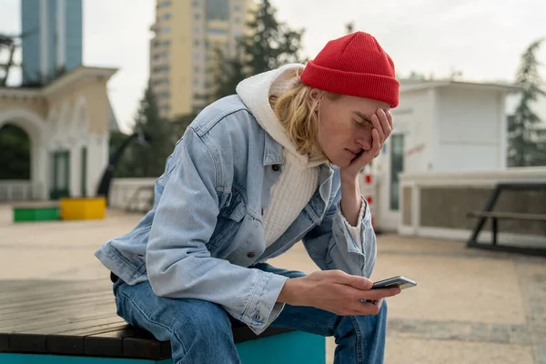 Besorgter Aufgebrachter Millennial Kerl Der Mit Smartphone Der Hand Allein — Stockfoto