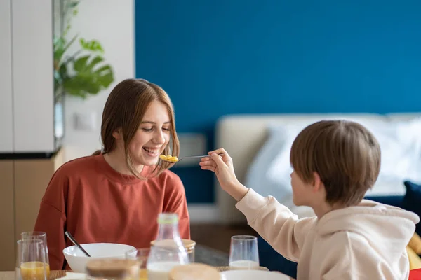 Brother Feeding Teen Sister Spoon Home Having Breakfast Together Friendship — Stock Photo, Image