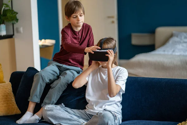 男孩和女孩在一起呆在家里的闲暇时间使用Vr设备 孩子们坐在沙发上使用虚拟现实耳机 玩游戏 探索沉浸的世界 — 图库照片