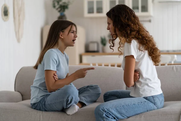 ソファの上でお互いの前に座っている間 自宅で母親の親と戦う怒って感情的な10代の少女の思春期の娘 選択的な焦点 10代と親の問題 — ストック写真