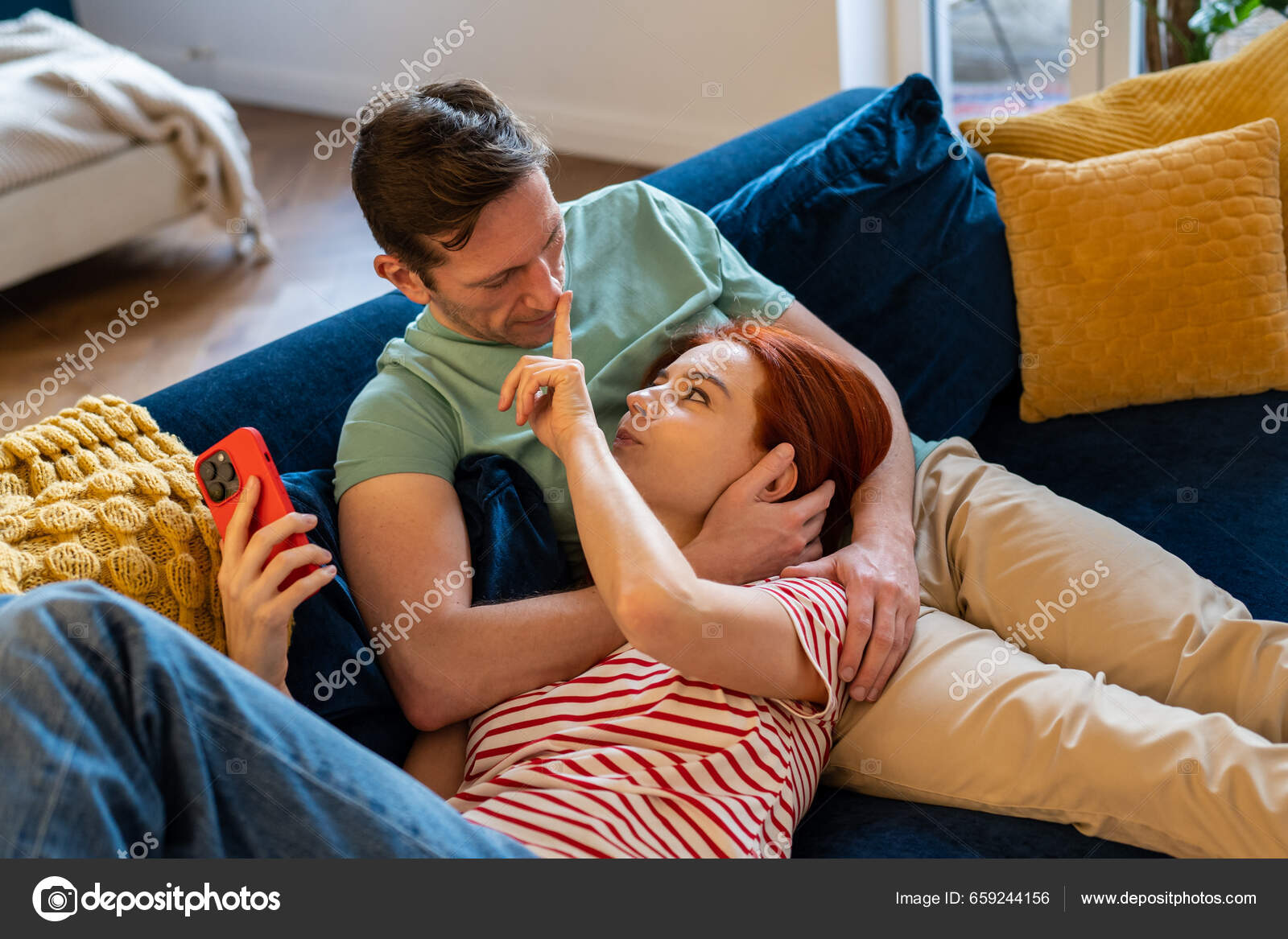 Rapaz sério jogando jogo online no celular, seus dois pais sentados perto  dele e olhando para a tela. família em casa e conceito de comunicação