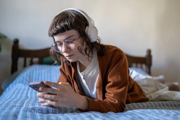 Scrollsucht Hipster Mädchen Mit Kopfhörern Schauen Auf Den Smartphone Bildschirm — Stockfoto