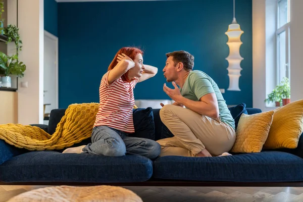 怒气冲冲的丈夫用手捂住耳朵冲妻子大喊大叫 白种人夫妻坐在沙发上 在家里吵架 在感情上产生误解 感情虐待 — 图库照片