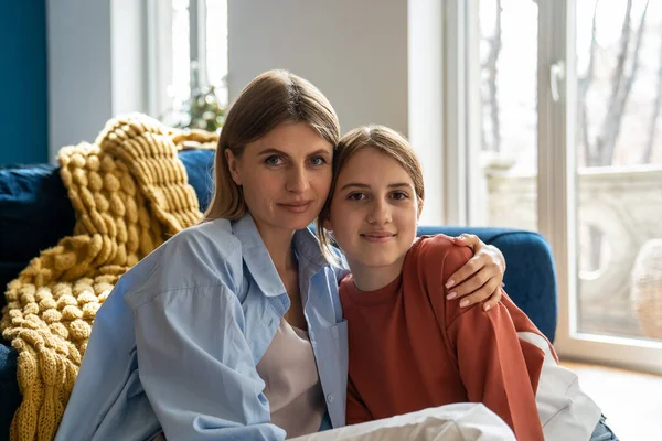 stock image Family portrait smiling mother and daughter looking camera. Parent and daughter spend time together home. Close relationship between child and parent. Mom hug girl, shows love, gratitude, affection