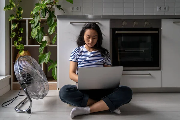 Allvarlig Asiatisk Kvinna Sitter Med Laptop Golvet Blåst Elektrisk Fläkt — Stockfoto