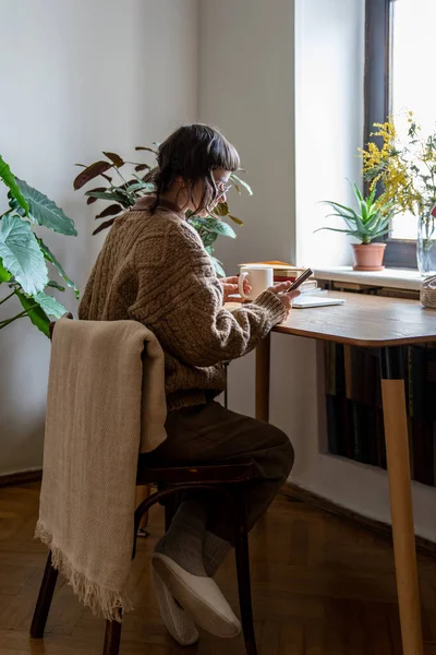 Teenie Mädchen Sitzt Schreibtisch Mit Tee Und Smartphone Während Sie — Stockfoto