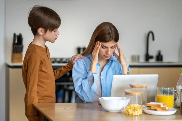 Besorgter Junge Beruhigt Aufgeregte Mutter Die Mit Laptop Küchentisch Sitzt — Stockfoto