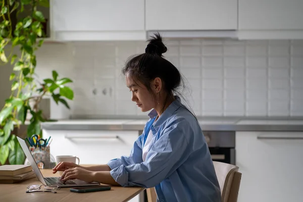 Escritora Freelancer Asiática Concentrada Digitando Laptop Sentada Mesa Cozinha Moderna — Fotografia de Stock
