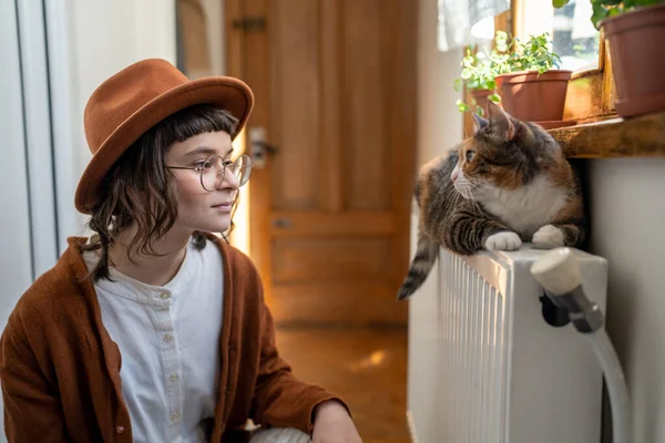 Interested Woman Cat Owner Hat Looks Fluffy Pet Lying Radiator — Stock Photo, Image