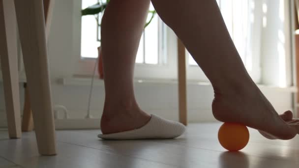 在长期久坐不动的工作中 女人用硅球在桌子下按摩脚 外伤后足部康复的体育锻炼 改善血液循环 预防腿疾病 — 图库视频影像