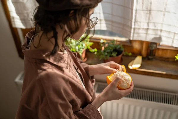 소녀들은 껍질에 창턱에 오렌지 기분좋은 기분을 느낀다 여자는 아파트에서 과일을 — 스톡 사진