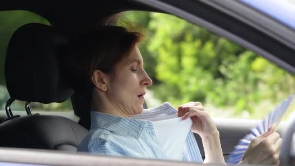 Уставшая Женщина Средних Лет Машущая Голубым Вентилятором Страдает Душного Вождения — стоковое видео